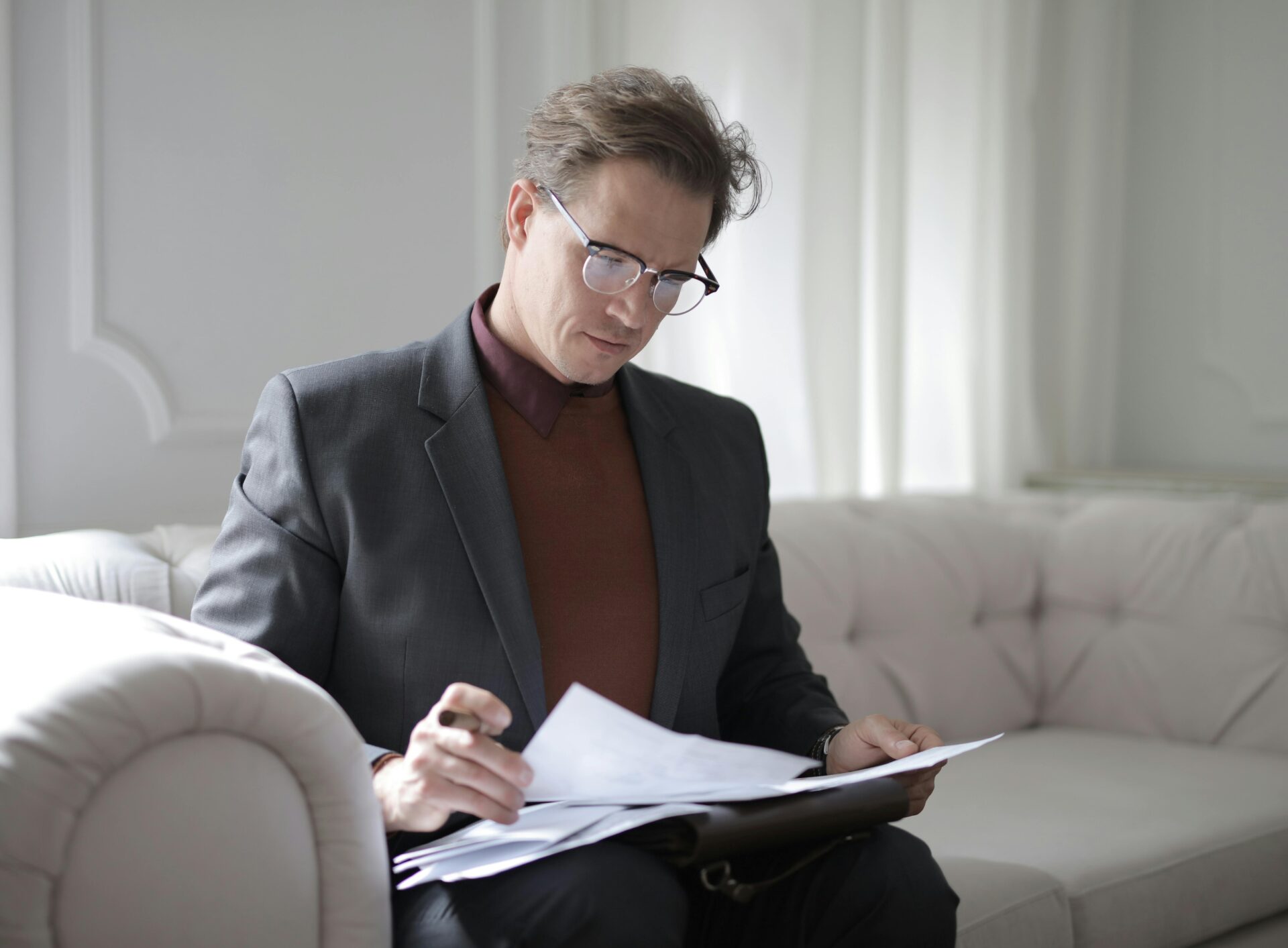 A man sitting in a chair looking at papers