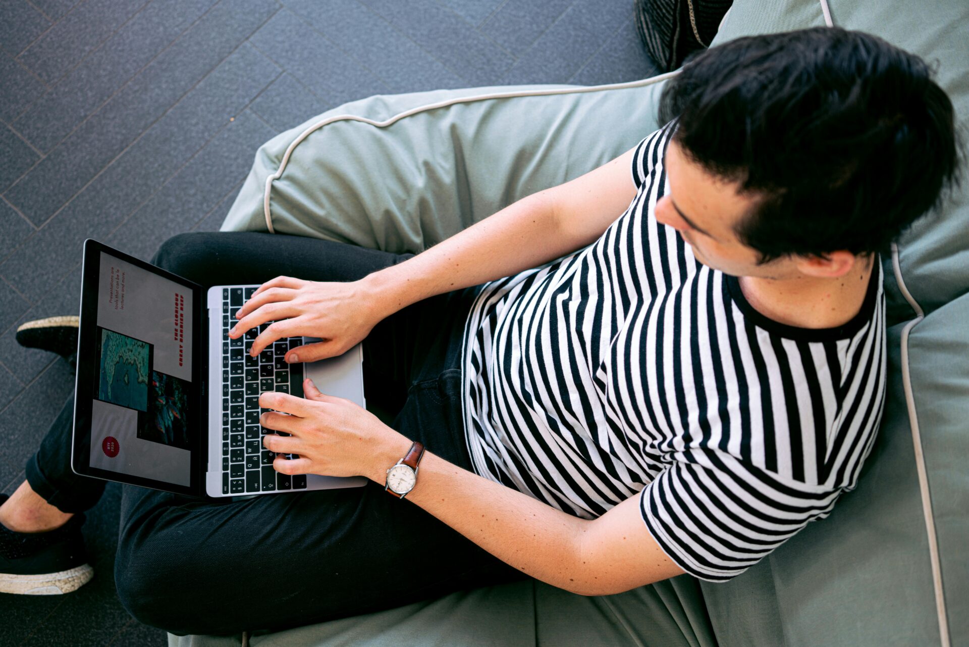 A person sitting down and typing on a laptop